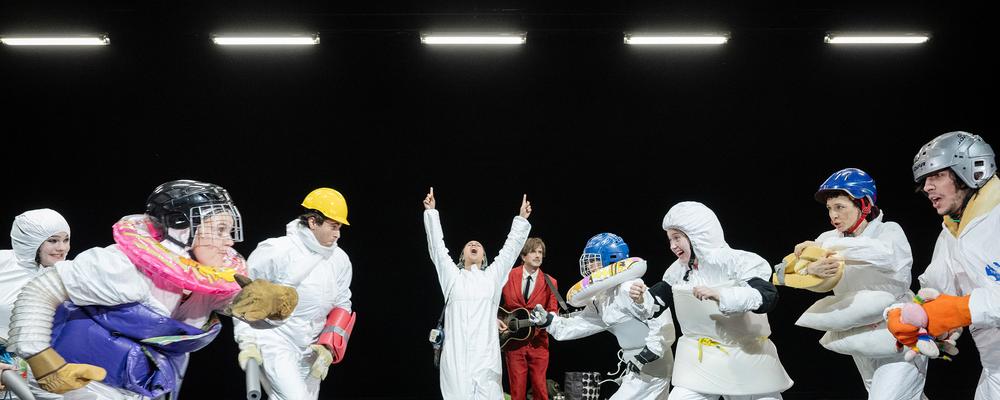 En grupp personer rör sig i ett svart rum