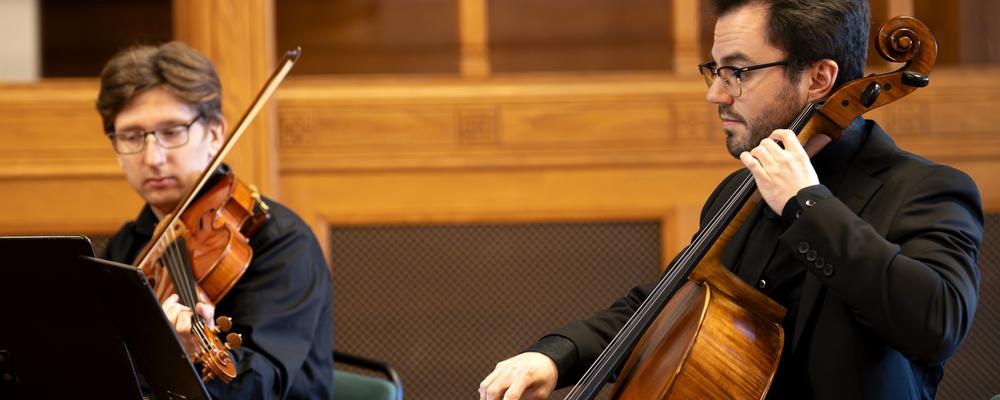 Two persons playing bowed string instruments