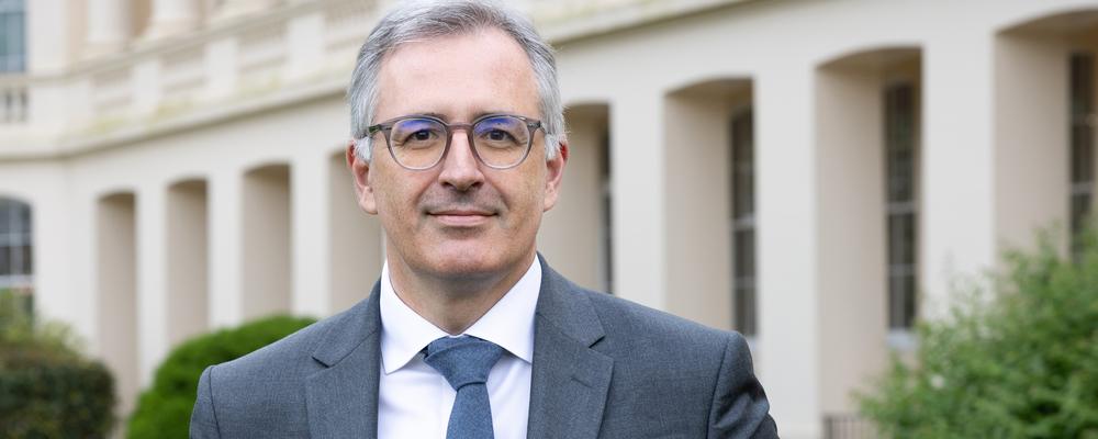 Sergei Guriev in front of a white building