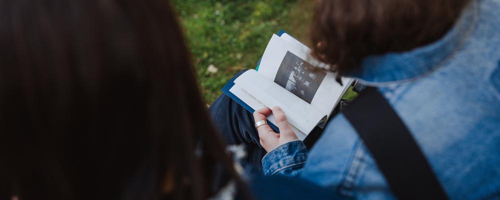 Två personer bläddrar i en bok