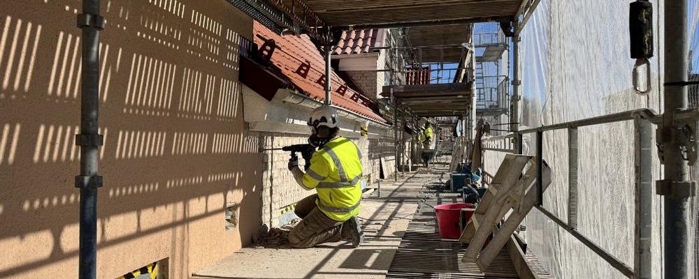 Alumn bilar puts på en husfasad, foto.