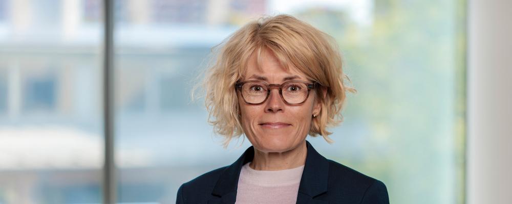 porträttfoto på kvinna i kort ljust hår och svart kavaj