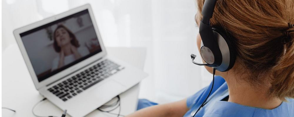 Sjusksköterska sitter i digitalt möte med patient 