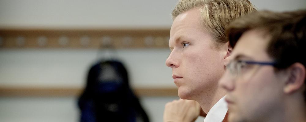 Två studenter sitter i ett klassrum och lyssnar koncentrerat