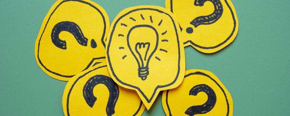 Bild på frågetecken och glödlampa i mitten, symboler för frågor och svar.