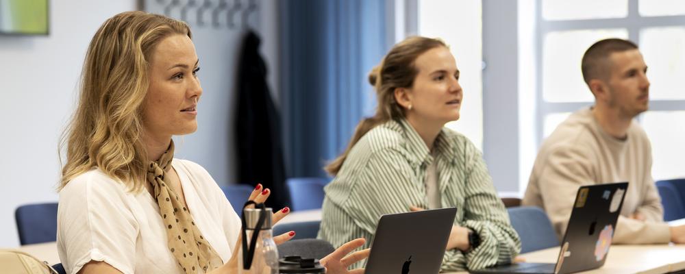 Bilden visar tre mastersstudenter under en lektion.