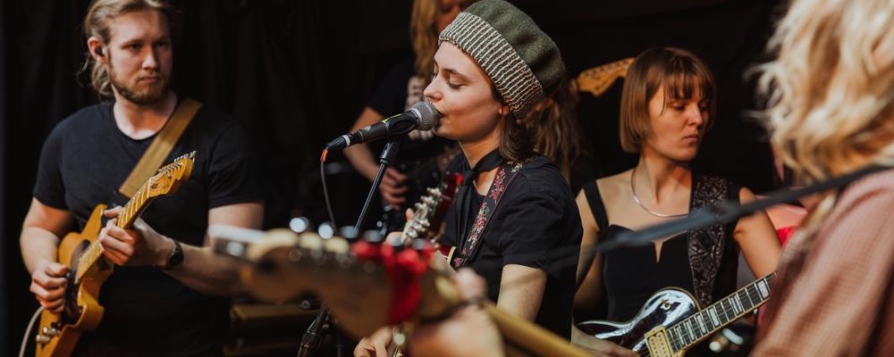 A group playing electric guitars and singing