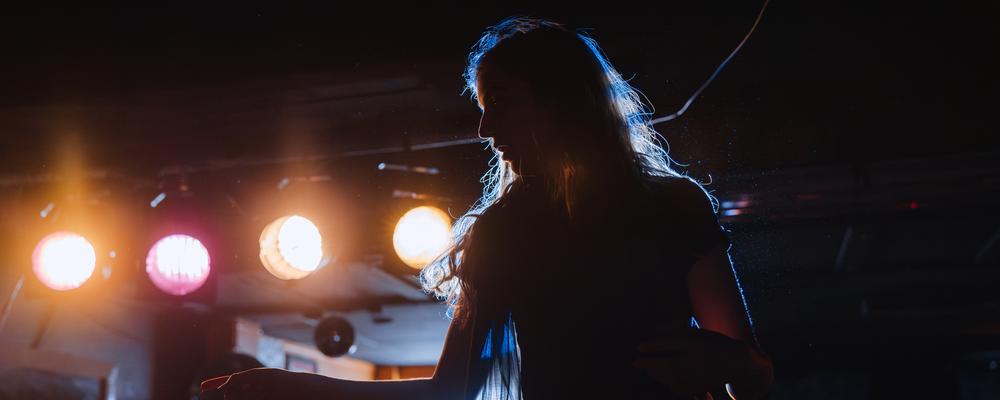 Student backlit by stage lighting