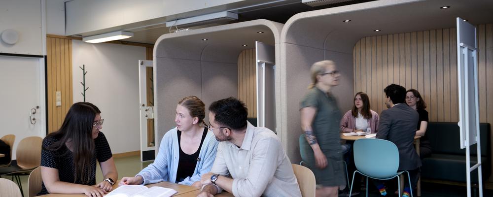 Studenter som sitter i ett atrium och pluggar