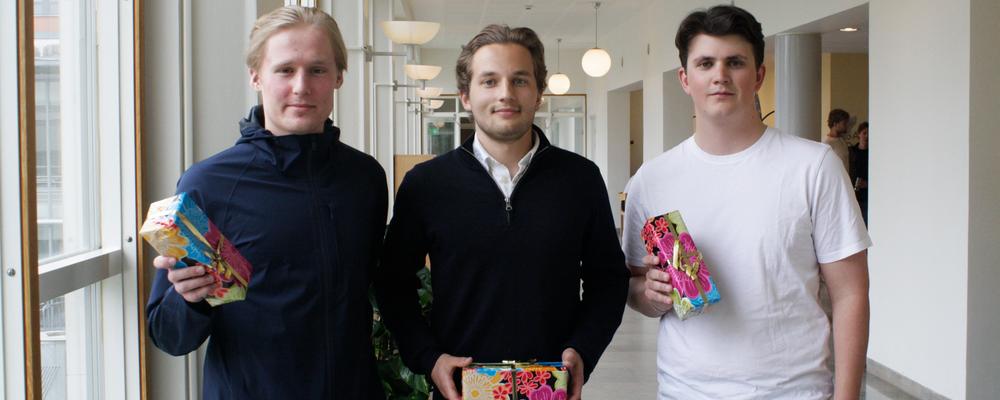 Foto på tre studenter framför Handelshögskolan