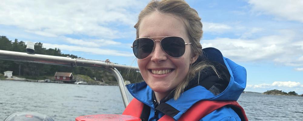 Marica Andersson in a boat, with a research buoy on her lap.