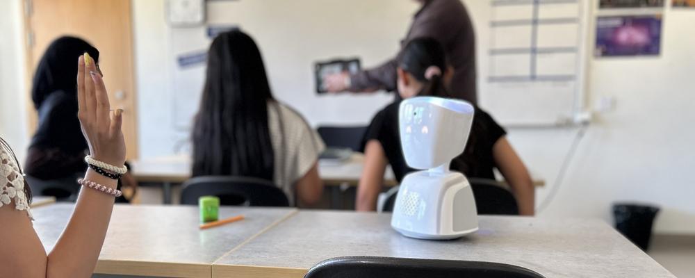 Bild på en skolrobot på en bänk i ett klassrum