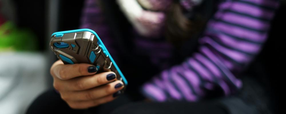 Närbild av ungdom med mobiltelefon