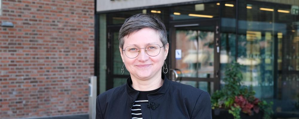 kvinna ler framför byggnad