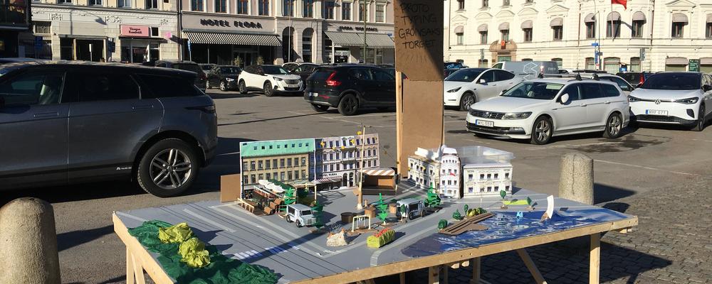 Bild på en stadsmiljö med ett bord med en miniatyr på samma stadsmiljö