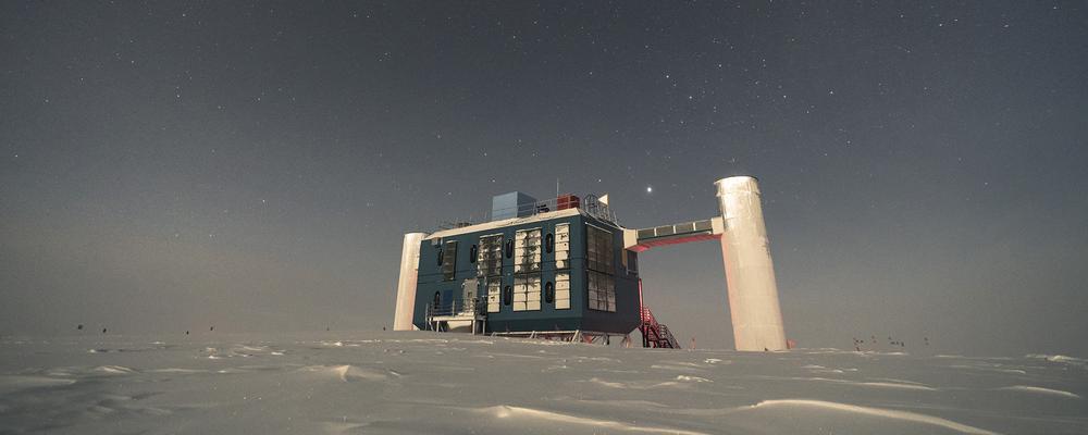 En stor byggnad på Antarktis is med stjärnhimlen i fonden