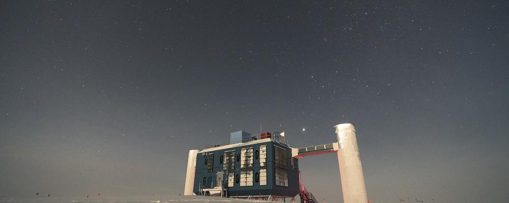 En stor byggnad på Antarktis is med stjärnhimlen i fonden
