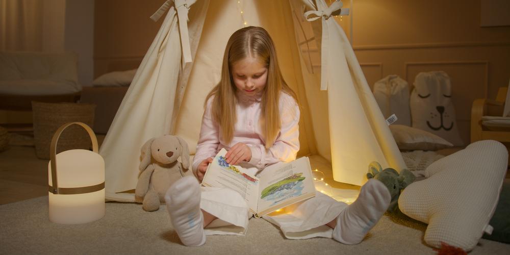 Young girl on the floor reading in her bedroom