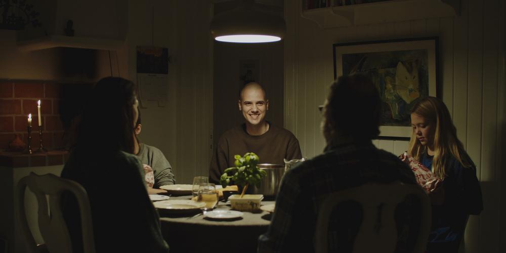 Still from The Drowning Goat - people around a table