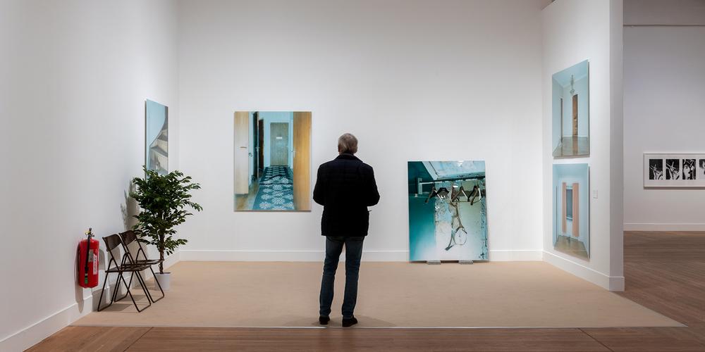En man tittar på bilder i en utställningshall