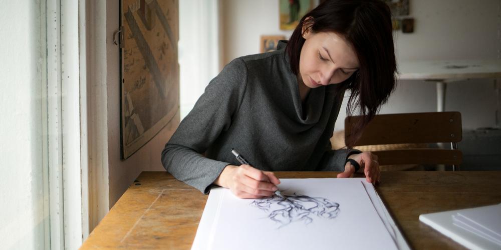 Maja Sikorska tecknar vid sitt skrivbord