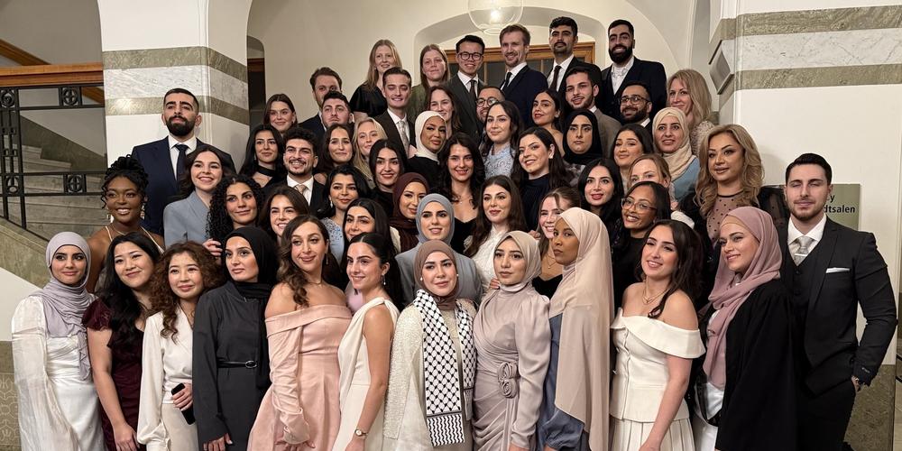 Nyexaminerade tandläkarstudenter i aulan.