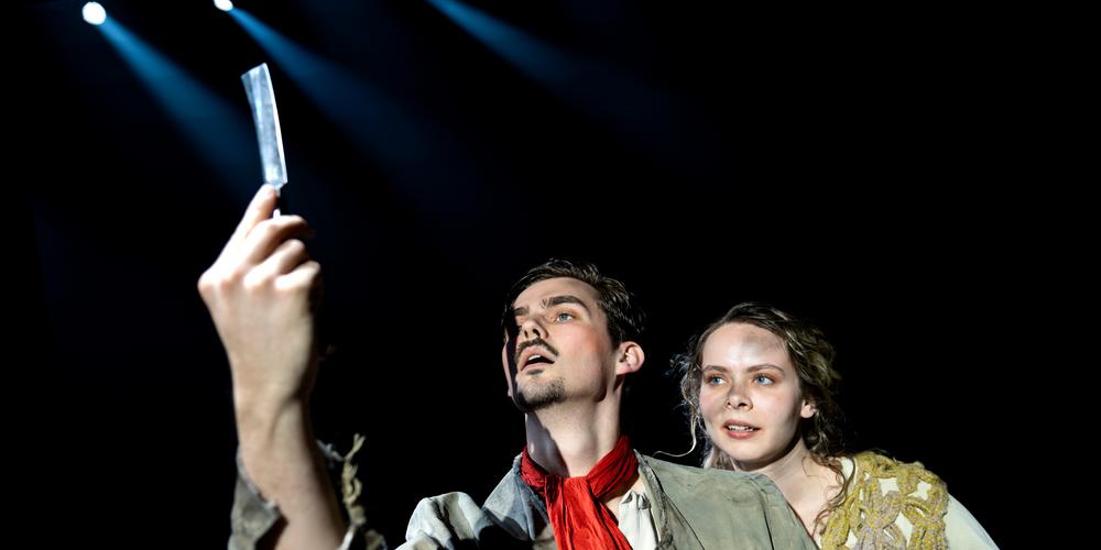 Två personer på scen: en håller en kniv i handen.