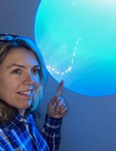 Porträtt på Christin Appelquist framför ett akvarium med ett självlysande trassligt havssnöre
