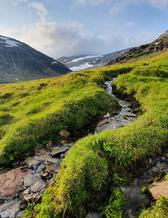 Vy över vacker natur med berg, skog och vatten i svenska fjällen. 