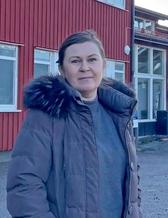 En kvinna står framför en röd labbyggnad.