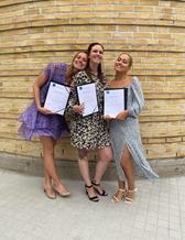 Tre studenter firar examen.