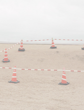 röda koner utplacerade i sand bredvid ett stängsel