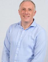 Leende man med ljusblå skjorta