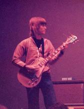 Jörgen as a young man with long hair and his guitar. 
