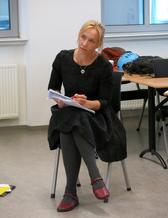 Kvinna sitter på stil och antecknar i undervisning