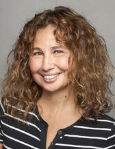 Porträttbild på en kvinna med krulligt hår