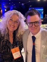 Mirjam and Axel are standing next to each other smiling at the conference venue.