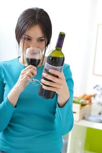 Women holding wine bottle and glass of wine