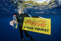 Dykare med plastflaskor och skylt: Coca Cola is this yours?