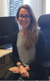 Person som sitter vid ett datorskrivbord vänt bort från skrivbordet 