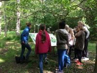 People gathered around a map in a forest
