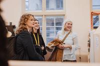 Tre besökare i testilkonststudenternas studio