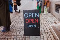 Gatupratare (skylt) med meddelandet Open i blått och rött.