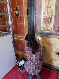 Student examining the Pompeii room mural paintings at Börsen, photo.