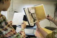 Händer som håller handskrivna böcker.