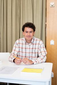 man som sitter vid ett vitt bord