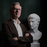 Kristian Göransson står bredvid en antik byst av kejsar Augustus.