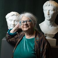 Porträtt av Barbro Wallgren Hemlin framför antika byster av romerska kejsare.