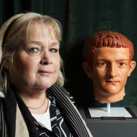 <Porträtt av forskare bredvid antik byst>