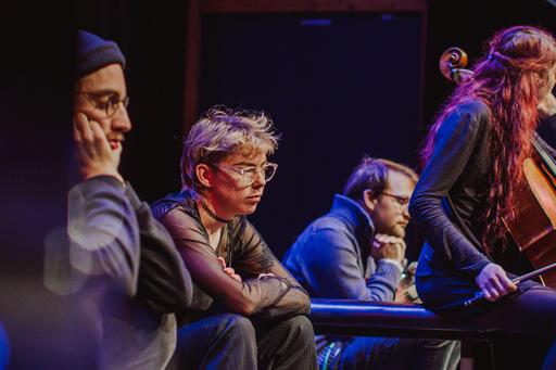 Fyra musiker sitter på en scen och lyssnar.